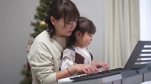 Woman Teaches Child to Play Keyboard at Home