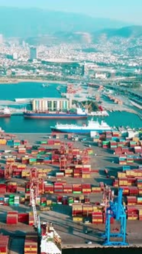 Vertical video of the port - Drone footage of containers, cargo ships and loading cranes in the port