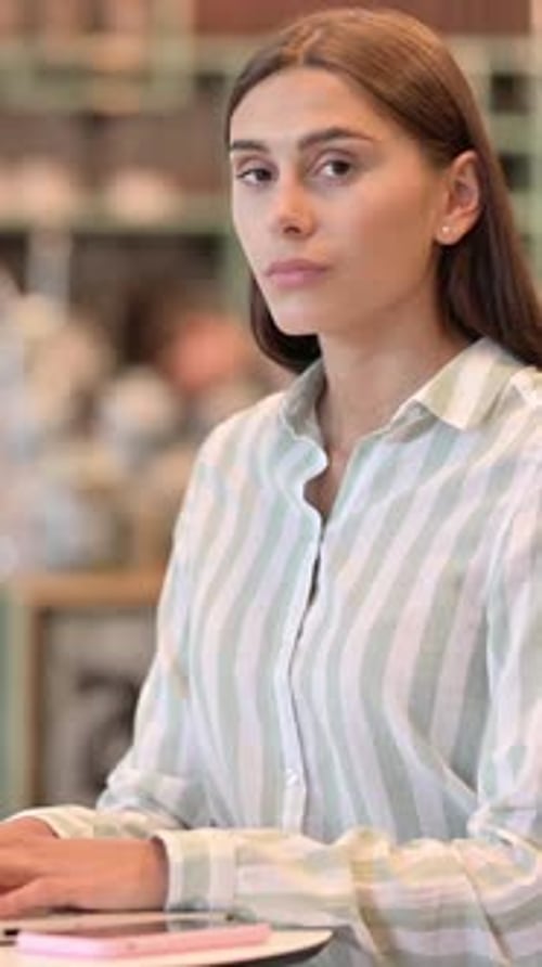Woman Using Laptop Computer in Bright Cafe