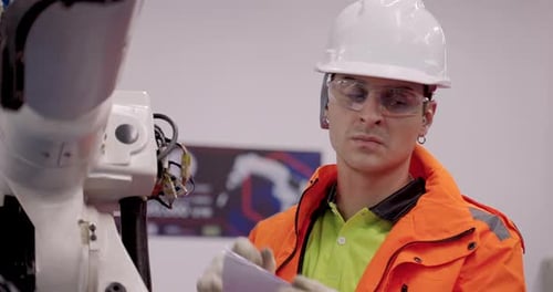 Man Working on Technology in Factory Setting