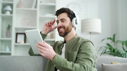 Man Relaxing on Couch With Tablet and Headphones