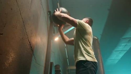 Athletic Man Performing Wall Ball Exercises During a CrossTraining Workout