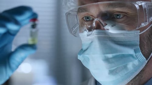 Medical Worker Examining a Vial in Laboratory Close Up