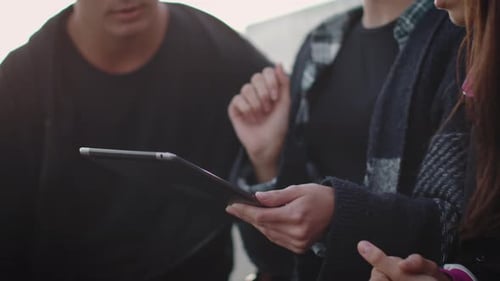 Young Adults Collaborating Using a Tablet Outdoors