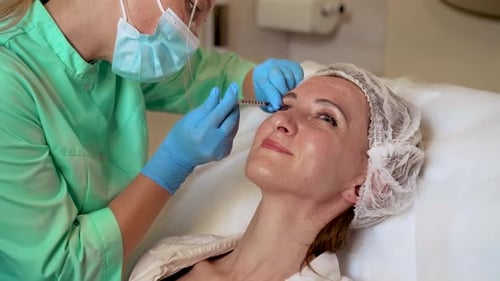 Woman Receiving Cosmetic Injection Near Eye