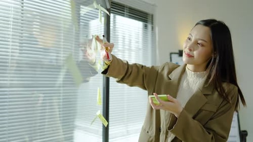 Professional Woman Brainstorms with Sticky Notes in Office