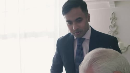 Man in suit talking to senior male