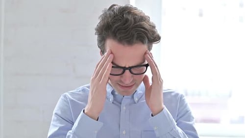 Man Rubs Temples Suffering from Headache Pain
