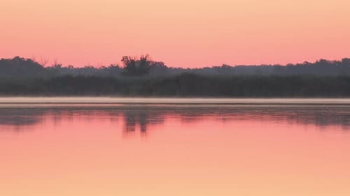 Early morning on calm river with fog. Sunrise over lake and beautiful morning landscape