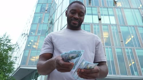 African American Man Holding Money Dollar Bills on Urban Street in City Businessman Guy Counting