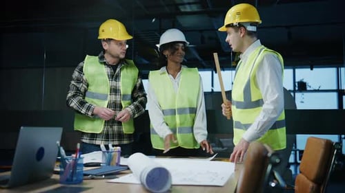 Construction Team Discussing Blueprints in a Modern Office