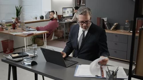 Man in Suit Working at Desk in Office