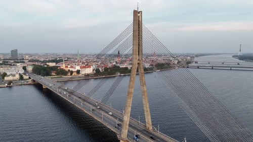 Luftaufnahme des Flusses Daugava und der Vansu-Brücke in Riga am frühen Morgen bei Sonnenaufgang auf klarem Himmel