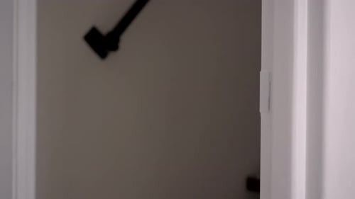 Hand Opens Interior White Door to Grey Room
