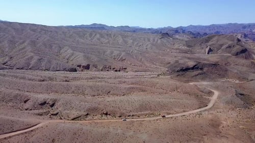 Aerial view following traffic on a desert road, in Kingman, USA - pan, drone shot