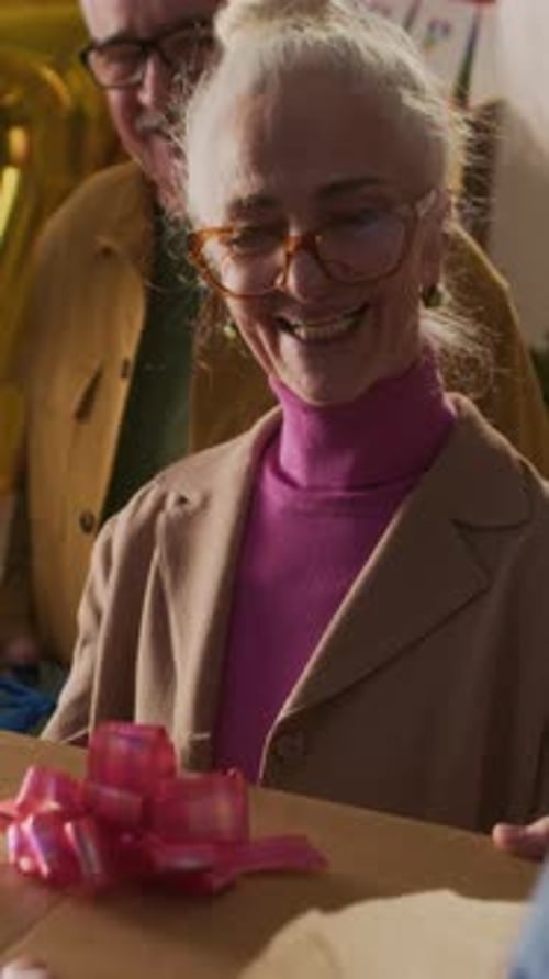 Happy Senior Couple Receiving Birthday Gifts at Party