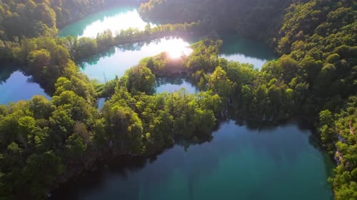 Mountain lake and dense forest landscape in summer to early autumn sunny day morning. Sparkle clear