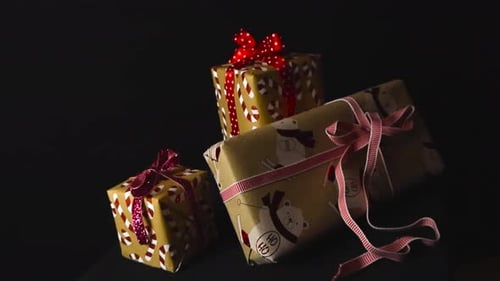 Holiday gifts or Merry Christmas presents with candy cane wrapping paper and red ribbons, studio.