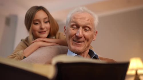 Retrato de un hombre mayor caucásico positivo hablando recordando recuerdos viendo un antiguo álbum de fotos con