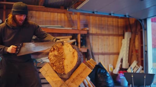 Male Worker Manually Cutting Tree Log With Hand Saw. medium static shot