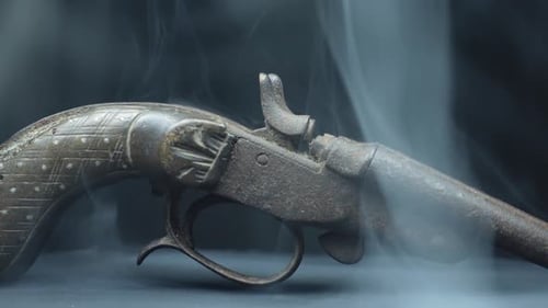 Antique Pistol envolved by white smoke