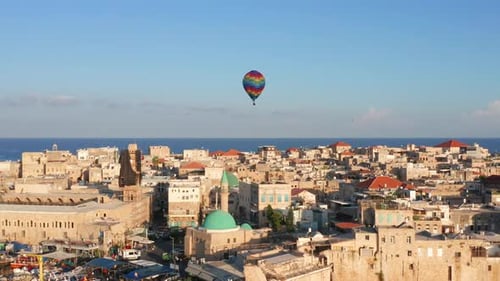 Hot air balloon passing over Acre old city port houses and Mosque at sunrise, Aerial view