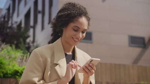 Smiling Woman Using Smartphone in Urban Setting