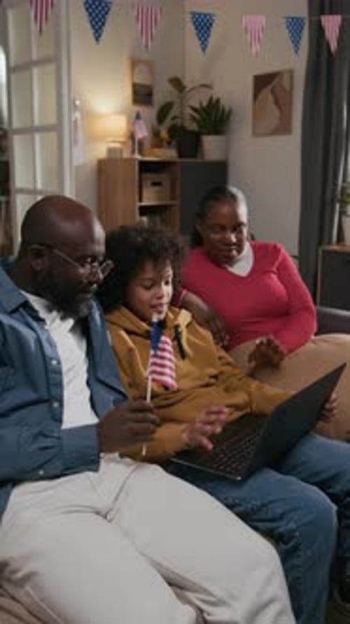 Family Enjoys Laptop Together with American Flag