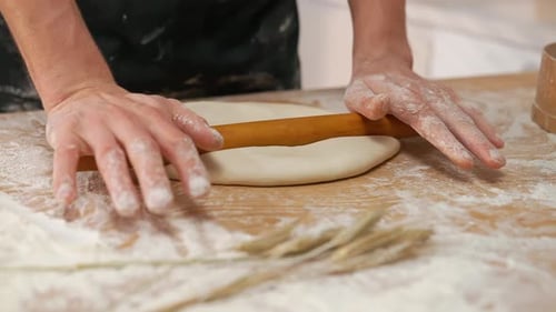 Hands Roll Dough with Wooden Rolling Pin