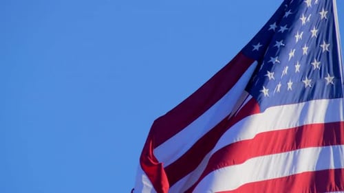 American Flag Waving Against Clear Blue Sky