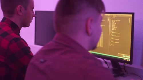 Zwei Männer arbeiten als Programmierer, die nebeneinander an einem Tisch sitzen