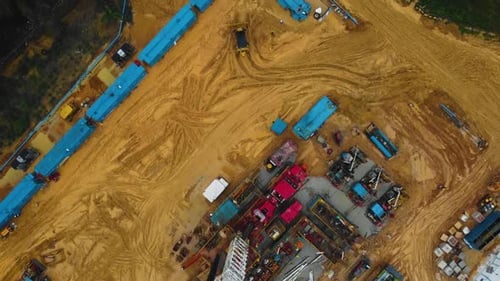 Luftaufnahme von schweren Maschinen, die auf einer belebten Baustelle arbeiten