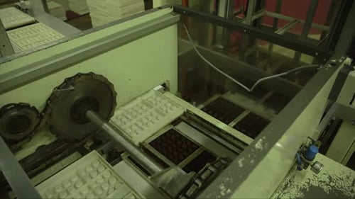 candy molds are separated from a package of chocolates in a chocolate factory