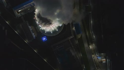 Upper View Brightly Lit Cooling Tower with Steam Pillar
