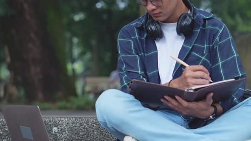 Asian Man College Student Studying In A Park