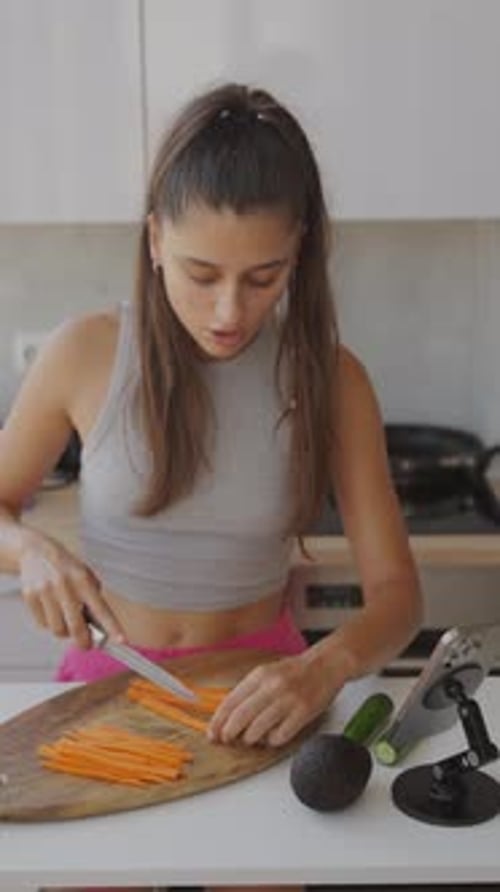 Woman Cutting Carrots in Kitchen for Healthy Meal