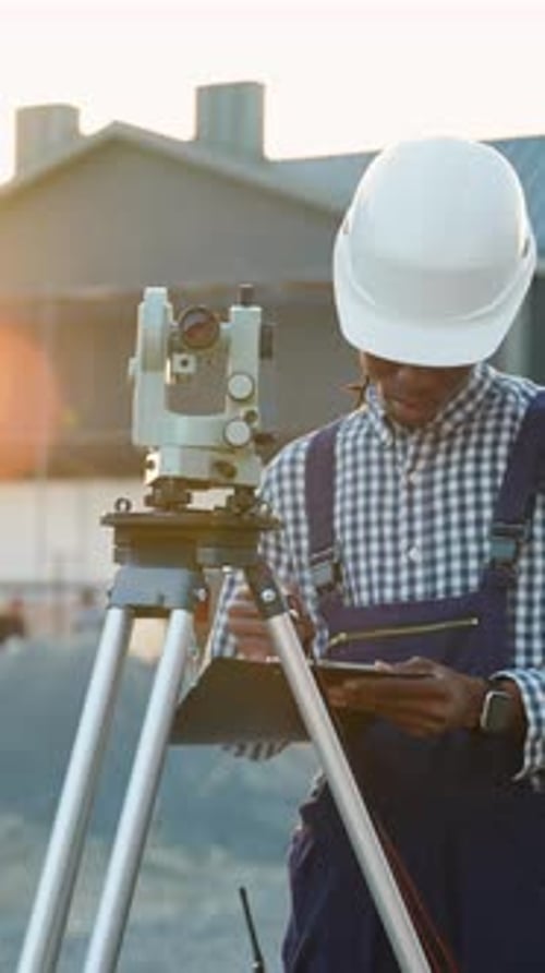 Ingénieur géomètre utilisant le théodolite pour mesurer sur un chantier de construction