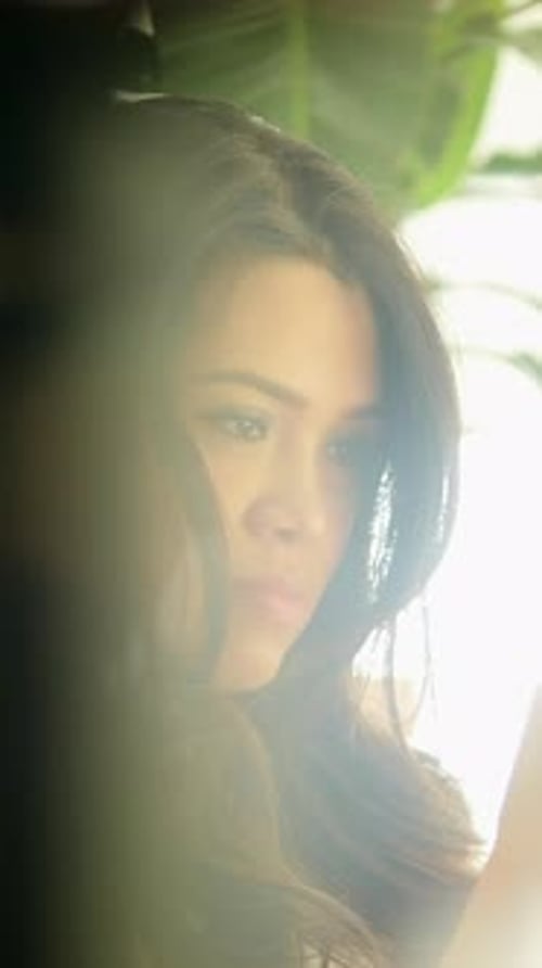 Portrait contemplatif d'une femme illuminée par la lumière naturelle dans un cadre artistique