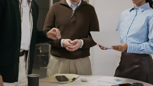 Colleagues Discussing Data at Desk in Modern Office