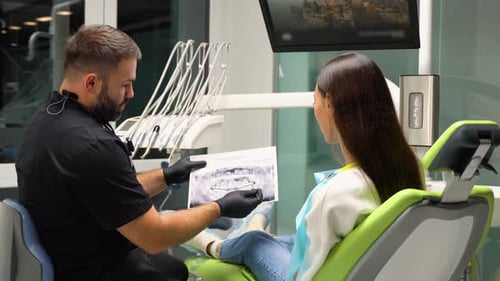 Zahnarzt erklärt in der Zahnklinik die Mundpflege vom Zahnröntgen bis zum Patienten