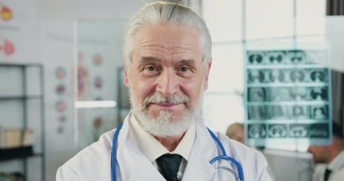 Close up portrait of doctor which looking into camera with sincerely smile in hospital workroom