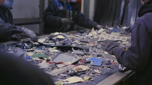 Workers Sorting Recycled Waste at Industrial Plant