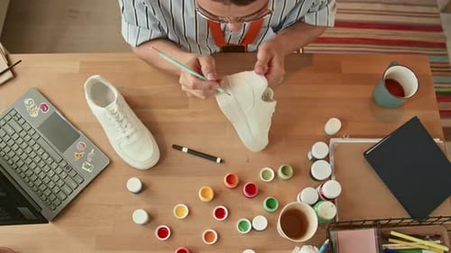 Young Adult Customizing a Sneaker with Paint