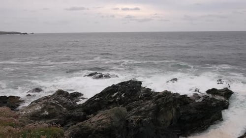 Powerful Ocean Waves Crashing Over the Rugged Exposed Rocks During High Tide
