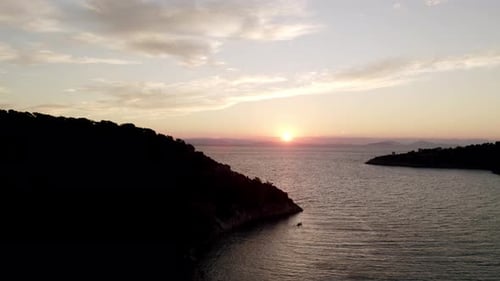 Aerial view on scenic seascape, waving sea, mountain and sunset at horizon