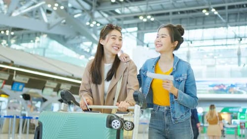 Asian young women talking together while waiting for airplane boarding.