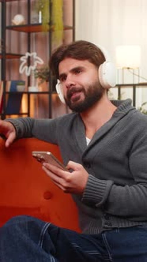 Man Listening to Music, Relaxing on Orange Couch