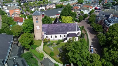 A stunning aerial view of a European town with a historic church and green fields stretching