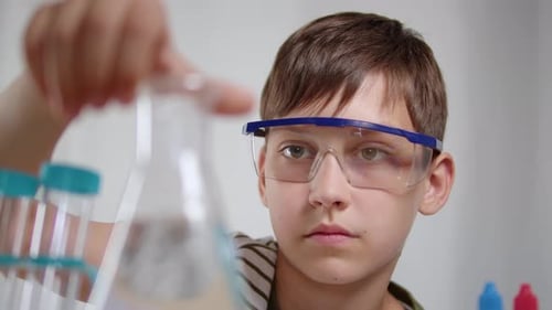 Boy with Safety Glasses Holding Scientific Beaker