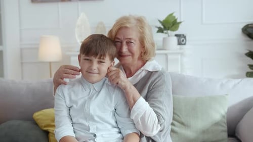 Grandmother and Grandson Sitting Together Smiling on Couch